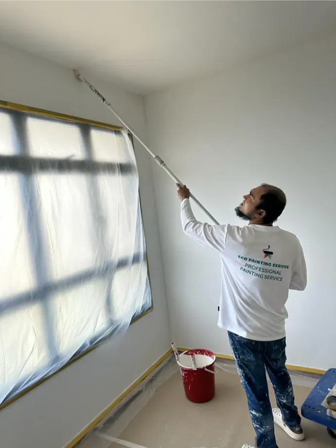 Eco Painting Service painter rolling a bedroom ceiling in a Singapore HDB flat with the window fully masked